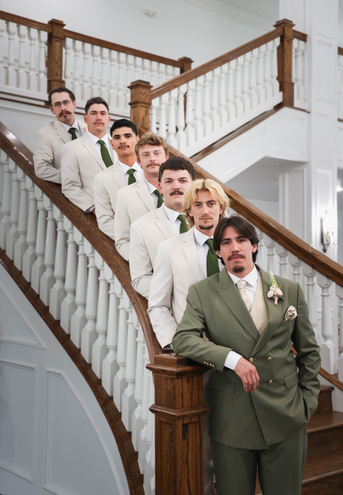 Groom and groomsmen posing on a staircase